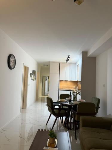 a living room and dining room with a table and chairs at Apartman Dukat- Luksuzna novogradnja u srcu Vinkovaca s parkingom in Vinkovci