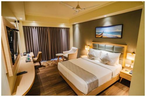 a hotel room with a bed and a television at Hotel Q Saina Aarokan Height Near Sea Beach And Jagannath Temple Puri in Puri