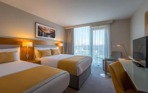 a hotel room with two beds and a television at Maldron Hotel & Leisure Centre Limerick in Limerick