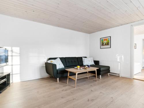 a living room with a black couch and a table at Holiday Home Alica - 200m from the sea by Interhome in Neksø