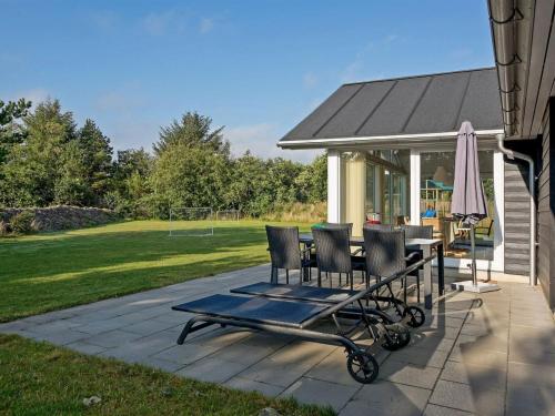 a patio with chairs and a table and an umbrella at Holiday Home Talida - 12km from the sea by Interhome in Oksbøl