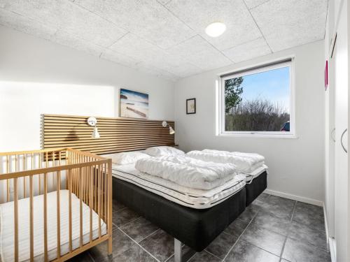 a bedroom with a large bed and a window at Holiday Home Talida - 12km from the sea by Interhome in Oksbøl