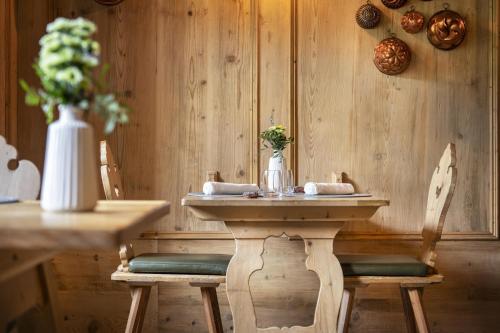 a table with two chairs and a table with a vase at Hotel Lac Salin Spa & Mountain Resort in Livigno