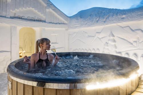 a young girl sitting in a hot tub at Hotel Lac Salin Spa & Mountain Resort in Livigno
