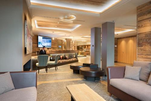 a lobby with couches and chairs and a fireplace at Hotel Lac Salin Spa & Mountain Resort in Livigno