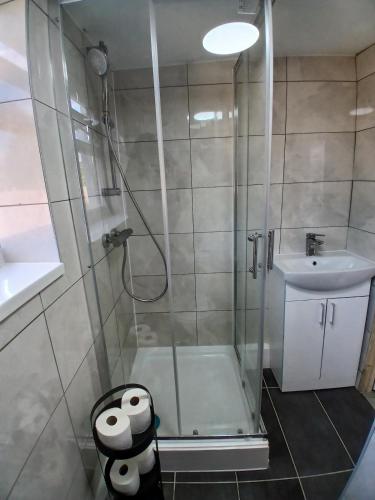 a bathroom with a shower and a sink at Rose Cottage-4 BED HOUSE FOR CONTRACTORS & FAMILIES Close to M6, J10-NO PARTIES ALLOWED in Walsall