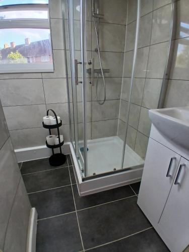 a bathroom with a shower and a sink at Rose Cottage-4 BED HOUSE FOR CONTRACTORS & FAMILIES Close to M6, J10-NO PARTIES ALLOWED in Walsall