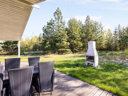 a table and chairs on a patio with a fireplace at Holiday Home Dwerg - 500m from the sea by Interhome in Jerup