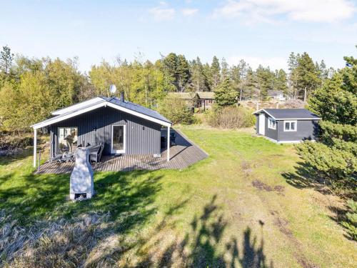 a house with a dog standing in the grass at Holiday Home Dwerg - 500m from the sea by Interhome in Jerup