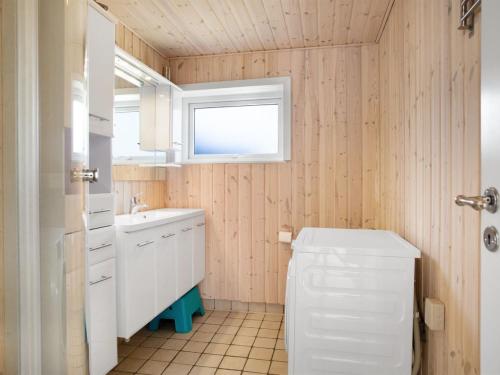 a bathroom with a toilet and a sink and a window at Holiday Home Dwerg - 500m from the sea by Interhome in Jerup