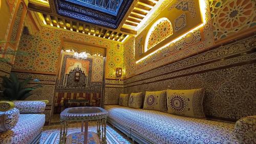 a room with a couch and a table on a wall at Riad Las mil y una noches 2 Tetuan in Tetouan
