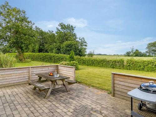 a picnic table on a brick patio with a fence at Holiday Home Thrine - 24km from the sea by Interhome in Bredebro