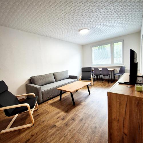 a living room with a couch and a table and chairs at Apartmánek Jizerské hory II in Josefuv dul