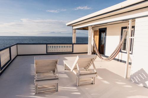 two chairs and a table on the deck of a cruise ship at Coral View Beach Resort in Utila