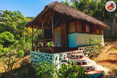 a small house with a thatched roof at Djema Forest in Nosy Be