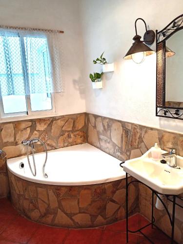 a bath tub and a sink in a bathroom at Apartamentos María Gaviota in Prado del Rey
