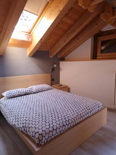 a bedroom with a bed in a room with wooden ceilings at Cesa Pegghy in Canazei