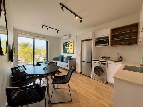 a kitchen and living room with a table and chairs at Mountain Whisper - Le Jardin Unit 306 in George