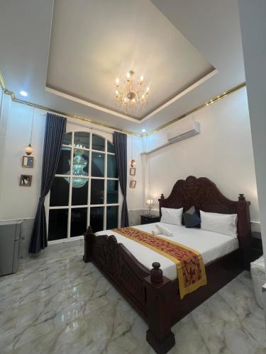 a bedroom with a large bed and a window at Manichan guesthouse in Pakse