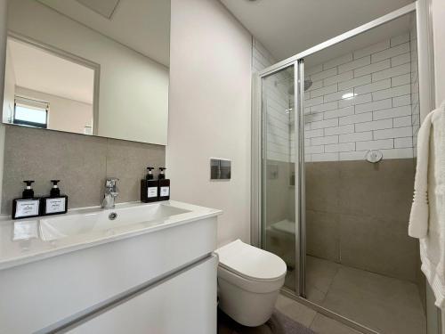a bathroom with a sink and a toilet and a shower at Mountain Whisper - Le Jardin Unit 306 in George