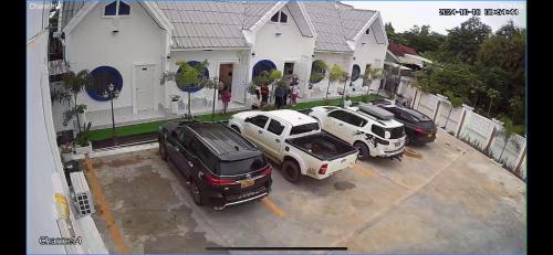 three cars parked in a parking lot in front of a house at Manichan guesthouse in Pakse