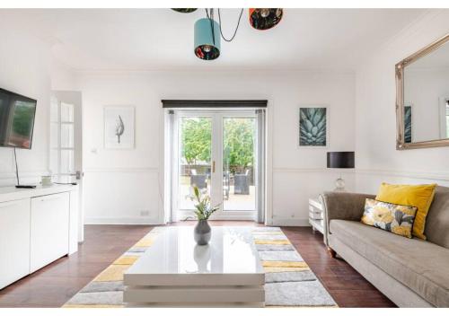 a living room with a couch and a coffee table at Elegant Flat in a Serene Edinburgh Neighbourhood in Edinburgh