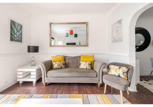 a living room with a couch and a mirror at Elegant Flat in a Serene Edinburgh Neighbourhood in Edinburgh