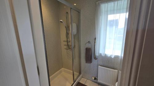 a bathroom with a shower with a glass door at The Pitfour Arms Hotel in Mintlaw