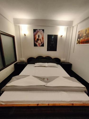 a bedroom with two beds and two pictures on the wall at Thejasmit Mount View Homestay in Kalimpong