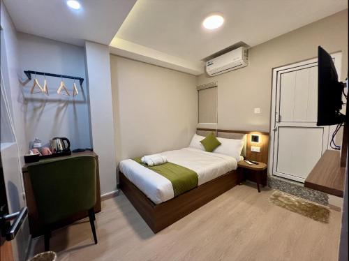 a hotel room with a bed and a television at The Old Alley Hotel & Apartment in Kathmandu