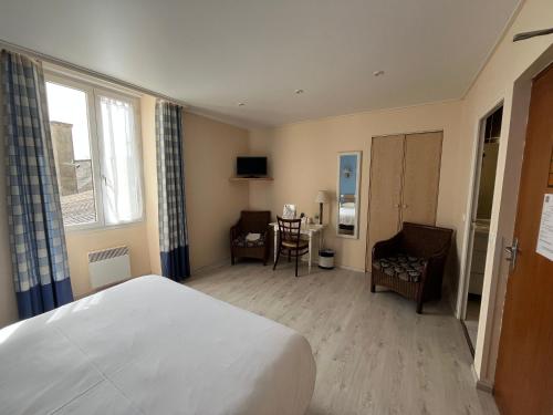 a hotel room with a bed and a table and chairs at Logis Hôtel & Restaurant - Le Bretagne in Sillé-le-Guillaume