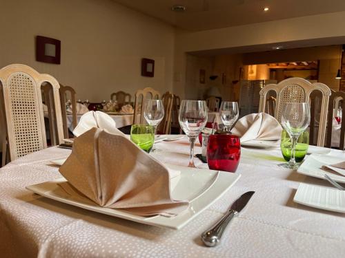 a table with a white table cloth and wine glasses at Logis Hôtel & Restaurant - Le Bretagne in Sillé-le-Guillaume