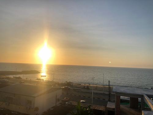 a sunset over the ocean with the sun in the sky at Monsoleil Hospedaria in Luanda
