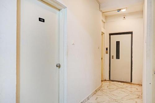 an empty corridor with a white wall and a door at Hotel O Silver Keys in Méribel Village