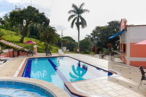 a pool at a resort with a palm tree at Escape to Nature in Copacabanas Hidden Gem in Copacabana