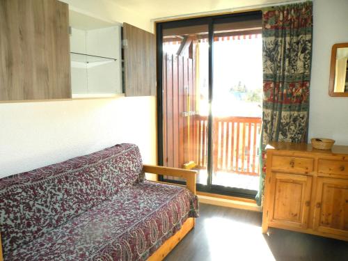 een slaapkamer met een bed en een glazen schuifdeur bij Studio accueillant aux Deux Alpes de 21 m² avec vue montagne in Les Deux Alpes