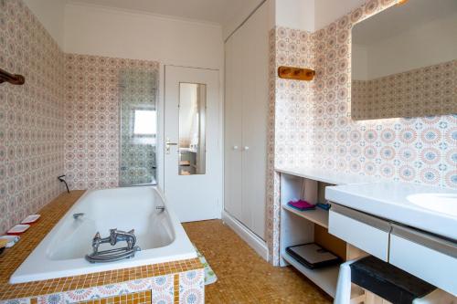 un baño con bañera y lavabo en Résidence musicale de Panissal, en Montignac