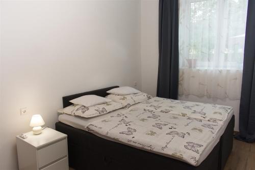 a bedroom with a bed with a black headboard and a window at Silver Dream Apartmanház in Debrecen