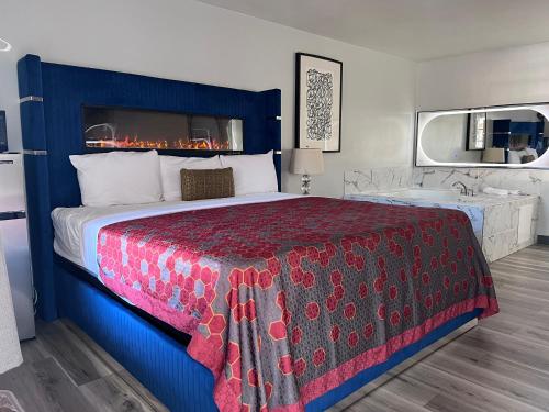 a hotel room with a bed and a bath tub at Capital O Elite Inn & Suites South Holland I 94 in South Holland