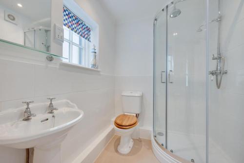 ein Badezimmer mit Toilette, Waschbecken und Dusche in der Unterkunft Twitten Cottage in Southwold