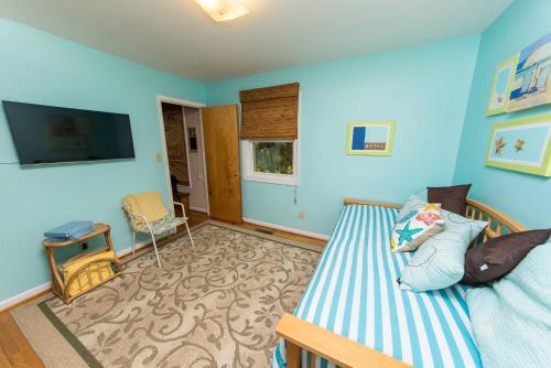 a blue room with a bed and a tv at Pappia in Duck