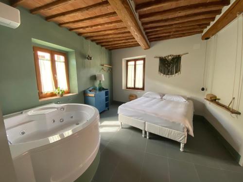a bathroom with a tub and a bed in it at Transito divino Gaiole in Gaiole in Chianti