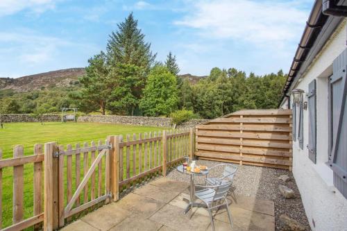 a patio with a table and a fence at 1 Bed in Newtonmore oc-b32417 in Newtonmore