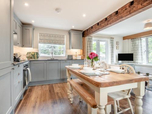 a kitchen with a wooden table with flowers on it at 2 Bed in Godshill 96127 in Godshill