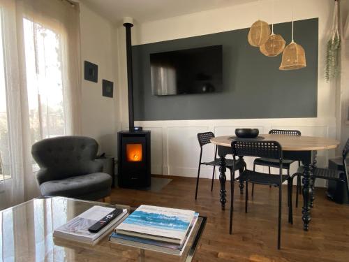 a living room with a table and a fireplace at Le 7 in Mesland