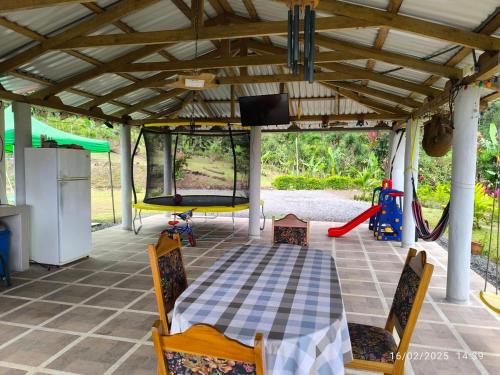 a patio with a table and chairs and a play area at Pacayitas El Camino House in Turrialba