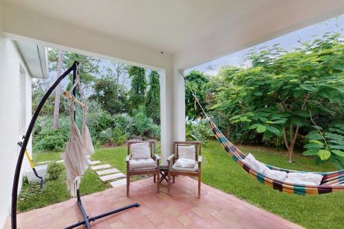a room with two chairs and a hammock at Captain's Quarter in Sebastian