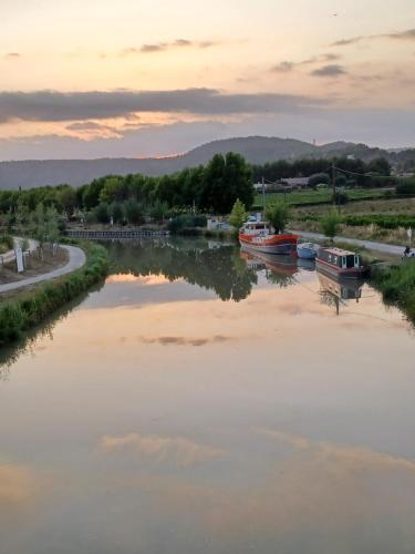 a river with boats in it at sunset at Le colibri bleu in Argeliers
