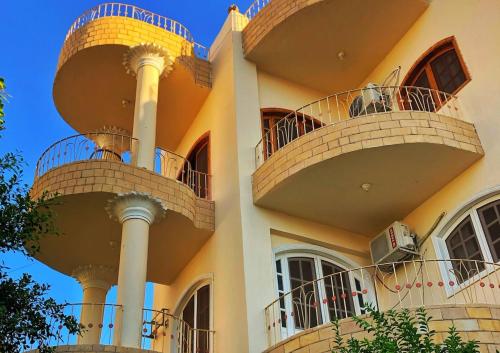 a building with three balconies on the side of it at Ozera villa - west bank in Luxor