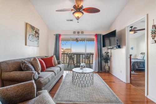 a living room with a couch and a ceiling fan at Baywatch A10 in Pensacola Beach